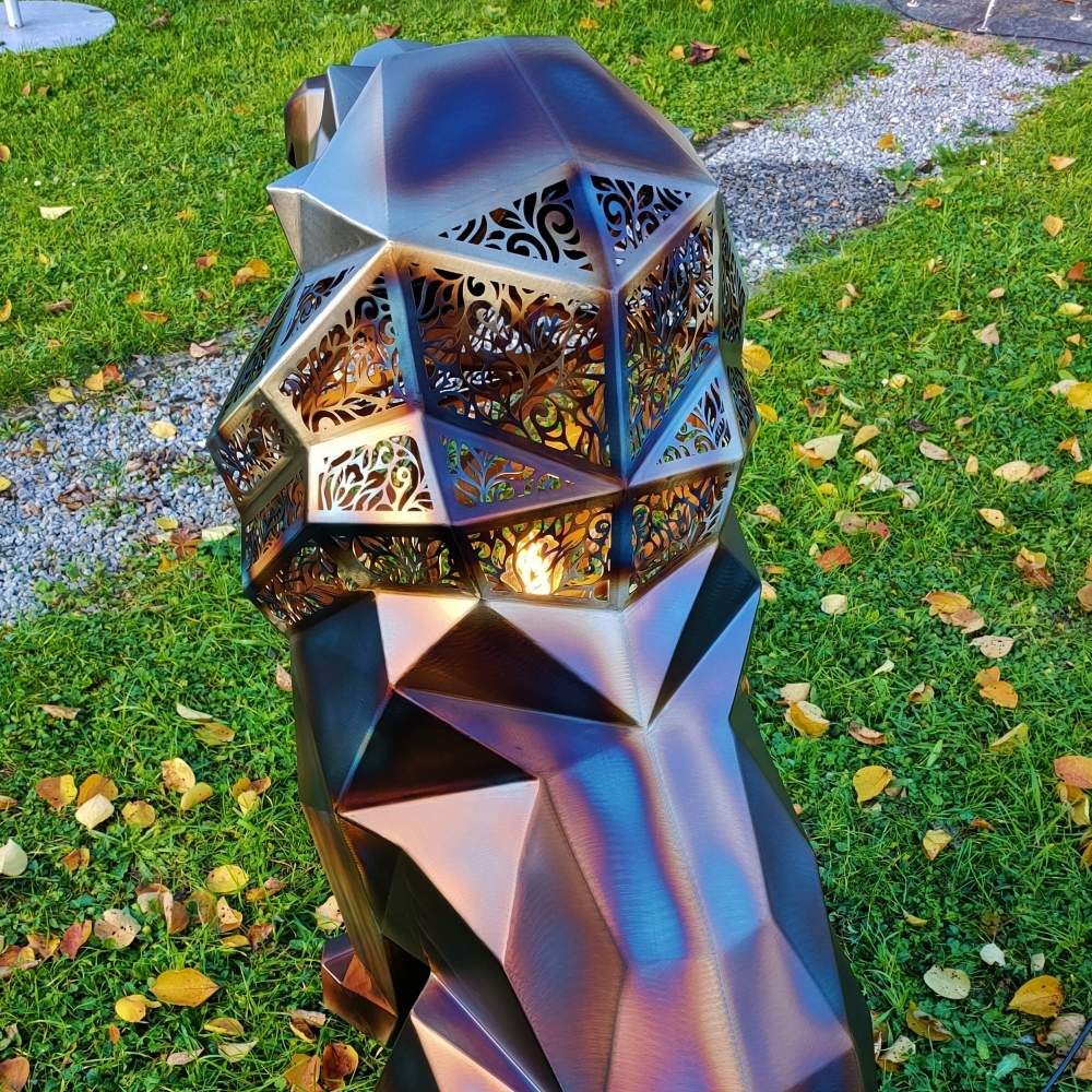 Golden polygonal lion sculpture with geometric laser-cut sections, seated in a garden